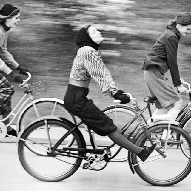black and white photo of women riding bikes